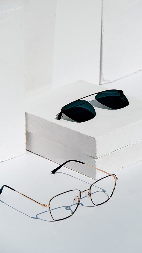 Minimalist scene of eyeglasses and sunglasses on a white studio setup, perfect for eyewear collections.